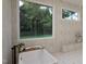 Relaxing bathroom featuring a soaking tub, large windows with natural views, and stylish tile flooring at 3612 Bailey Meadows Drive Dr, Wake Forest, NC 27587