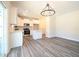 Bright kitchen with stainless appliances, white cabinets, granite countertops, and modern chandelier at 335 Tobacco Barn Dr, Angier, NC 27501