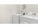 Bright laundry room featuring a white washer and dryer, plus wire shelving for storage at 3604 Drafton Dr, Raleigh, NC 27610