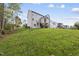 Sloping backyard with lush green grass and mature trees, perfect for outdoor activities at 2506 Silas Peak Ln, Apex, NC 27523