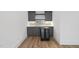 Charming bar area with sleek cabinets, wine fridge, quartz counters, and stylish mosaic tile backsplash at 2506 Silas Peak Ln, Apex, NC 27523