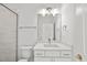 Modern bathroom features white cabinetry, a large mirror, and a tiled shower at 2506 Silas Peak Ln, Apex, NC 27523