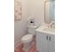 A powder room with an elongated toilet and white fixtures and orchid for staging at 2506 Silas Peak Ln, Apex, NC 27523