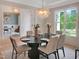 Elegant dining room with modern light fixture, table set for six, and wainscoting at 2506 Silas Peak Ln, Apex, NC 27523