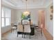 Elegant dining room with modern light fixture, table set for six, and wainscoting at 2506 Silas Peak Ln, Apex, NC 27523