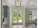 Bright foyer with double doors, wood floors, and modern lighting fixture offers a warm welcome at 2506 Silas Peak Ln, Apex, NC 27523
