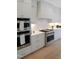 Modern kitchen featuring stainless steel appliances, double ovens, and plenty of storage space at 2506 Silas Peak Ln, Apex, NC 27523