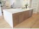 Kitchen island with a white countertop and brown cabinets, plus stainless steel appliances at 2506 Silas Peak Ln, Apex, NC 27523