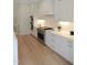 Modern white kitchen with stainless steel appliances, gas cooktop, and ample counter space at 2506 Silas Peak Ln, Apex, NC 27523