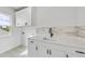 Well-lit laundry room featuring white cabinets, countertop, black faucet, and patterned floor tiles at 2506 Silas Peak Ln, Apex, NC 27523