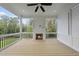 Inviting screened porch boasts a cozy fireplace, ceiling fan, and serene outdoor views at 2506 Silas Peak Ln, Apex, NC 27523