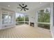 Inviting screened porch boasts a cozy fireplace, ceiling fan, and serene outdoor views at 2506 Silas Peak Ln, Apex, NC 27523