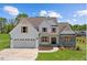 Charming two-story home featuring a white facade, stone accents, wooden shutters, and a neatly manicured lawn at 2568 Lassiter Rd, Four Oaks, NC 27524