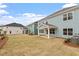 A view of the home's backyard, showcasing the lawn and covered patio area at 124 August Pond Way # 138, Raleigh, NC 27603