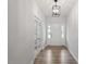 Bright entryway with wood floors, a stylish light fixture, and a view of the front door at 124 August Pond Way # 138, Raleigh, NC 27603