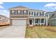 Charming two-story home featuring brick and siding, a two-car garage, and a welcoming front porch at 124 August Pond Way # 138, Raleigh, NC 27603