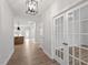 Inviting hallway featuring wood flooring, glass paneled doors, and a modern light fixture at 124 August Pond Way # 138, Raleigh, NC 27603