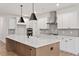 Modern kitchen with white cabinets, a large center island, and stainless steel range hood at 124 August Pond Way # 138, Raleigh, NC 27603