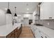 Modern kitchen with white cabinetry, stainless steel appliances, gray backsplash, and an island with a white countertop at 124 August Pond Way # 138, Raleigh, NC 27603