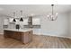 Spacious kitchen with white cabinets, stainless appliances, kitchen island, and hardwood floors at 124 August Pond Way # 138, Raleigh, NC 27603