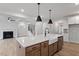 Open concept kitchen featuring an island with a white countertop, stainless steel appliances, and a farmhouse sink at 124 August Pond Way # 138, Raleigh, NC 27603