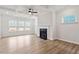 Bright living room featuring a modern fireplace, hardwood floors, tray ceilings, and large windows at 124 August Pond Way # 138, Raleigh, NC 27603