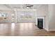Spacious living room with a modern fireplace, hardwood floors, coffered ceilings, and large windows at 124 August Pond Way # 138, Raleigh, NC 27603