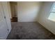 Spacious bedroom with carpet, access to another room, and an exterior view window at 1111 Woody Dr, Graham, NC 27253
