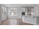Sunlit kitchen with stainless appliances, island, and a view of the neighborhood through large windows at 134 Black Walnut Dr # 205, Garner, NC 27529