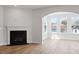 Living room with wood floors, fireplace, and archway to another room filled with light from the windows at 134 Black Walnut Dr # 205, Garner, NC 27529