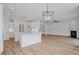 Open floor plan with kitchen island, fireplace, and modern chandelier for elegant living at 134 Black Walnut Dr # 205, Garner, NC 27529