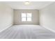 Bright bedroom featuring a large window and neutral carpet at 208 Regency Ridge Dr, Holly Springs, NC 27540