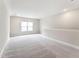 Spacious bonus room with neutral carpet, recessed lighting, and a bright window at 208 Regency Ridge Dr, Holly Springs, NC 27540