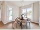 Sunlit dining area with round table, modern chairs, chandelier, and view to an outdoor patio at 208 Regency Ridge Dr, Holly Springs, NC 27540