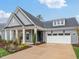 Charming home with a gray brick exterior, white trim, well-manicured landscaping, and a spacious driveway at 208 Regency Ridge Dr, Holly Springs, NC 27540