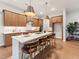 Modern kitchen featuring a large island with seating, wood cabinets, stainless steel appliances, and hardwood floors at 208 Regency Ridge Dr, Holly Springs, NC 27540