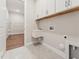 Practical laundry room equipped with a sink, upper cabinets, and shelving for efficient storage at 208 Regency Ridge Dr, Holly Springs, NC 27540