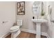 Elegant powder room with pedestal sink, oval mirror, and decorative wall art at 208 Regency Ridge Dr, Holly Springs, NC 27540