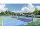 Community tennis courts with blue and green surfaces, surrounded by trees and benches at 208 Regency Ridge Dr, Holly Springs, NC 27540