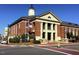 Classic brick town hall building with a clock tower and American flags at 208 Regency Ridge Dr, Holly Springs, NC 27540