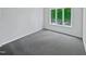 Bright bedroom featuring a large window offering plenty of natural light and gray carpeted floors at 104 Mossbark Ln, Chapel Hill, NC 27514