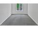 Bright bedroom featuring a large window offering plenty of natural light and gray carpeted floors at 104 Mossbark Ln, Chapel Hill, NC 27514