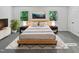 Staged bedroom with artwork, soft lighting, and light colored comforter at 104 Mossbark Ln, Chapel Hill, NC 27514
