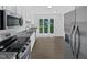 Well-lit kitchen with stainless steel appliances, granite countertops, and a window overlooking the yard at 104 Mossbark Ln, Chapel Hill, NC 27514