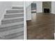 A carpeted staircase leading up to the living area and a view of the stone fireplace at 104 Mossbark Ln, Chapel Hill, NC 27514
