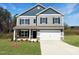 Charming two-story home features gray siding and black shutters with a well manicured lawn at 116 Bristow Ct # 49, Four Oaks, NC 27524