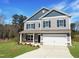 Charming two-story home features gray siding and black shutters with a well manicured lawn at 116 Bristow Ct # 49, Four Oaks, NC 27524