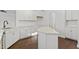 Modern kitchen showcasing a central island, white cabinetry, stainless steel sink, and sleek design elements at 125 Bold Dr, Youngsville, NC 27596