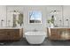 Elegant bathroom featuring a freestanding tub, double vanity, large mirrors, and modern lighting fixtures at 4800 Lakemont Dr, Raleigh, NC 27609