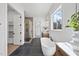 Bright bathroom featuring a freestanding tub, large shower, and and vanity with a view at 4800 Lakemont Dr, Raleigh, NC 27609